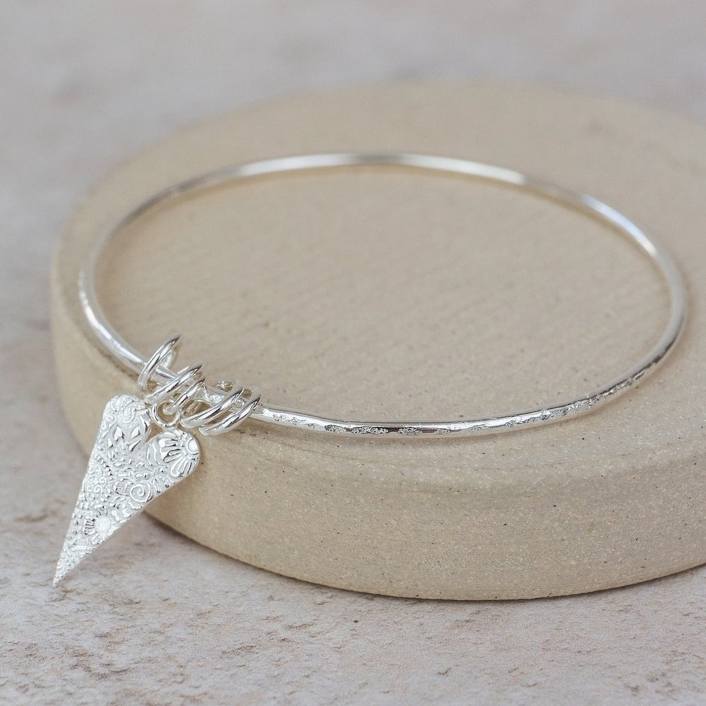 
                  
                    Sterling Silver Textured Long Heart Charm Bangle
                  
                