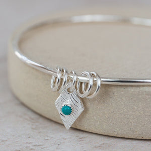 
                  
                    Sterling Silver Diamond and Turquoise Charm Bangle
                  
                
