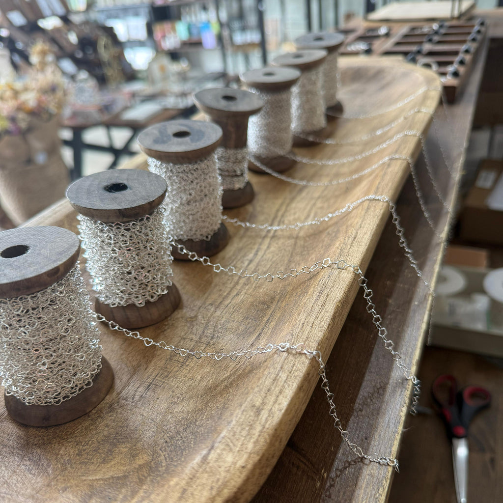 Wooden spools with chain on a wooden surface in a workshop setting
