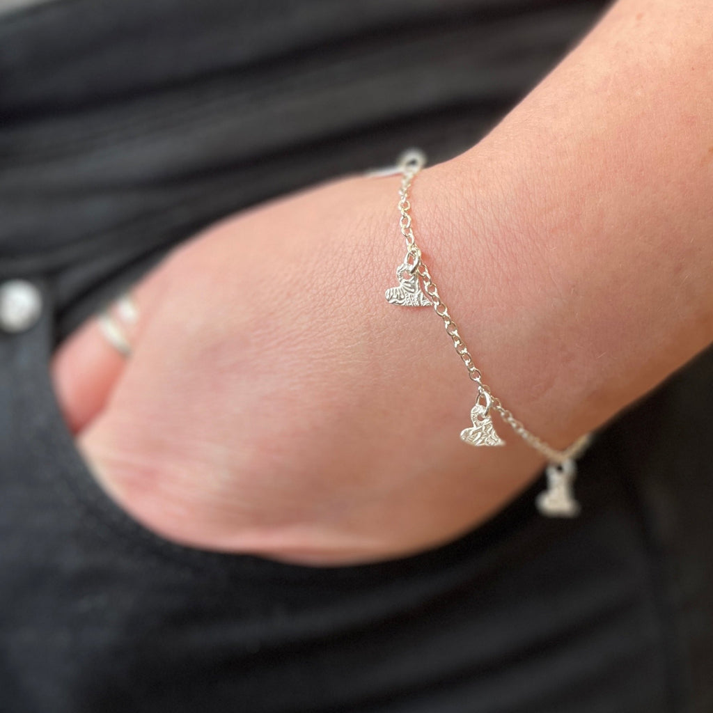 sterling silver textured tilted heart charm bracelet with delicate textures handmade by Lucy Kemp Jewellery, worn imag