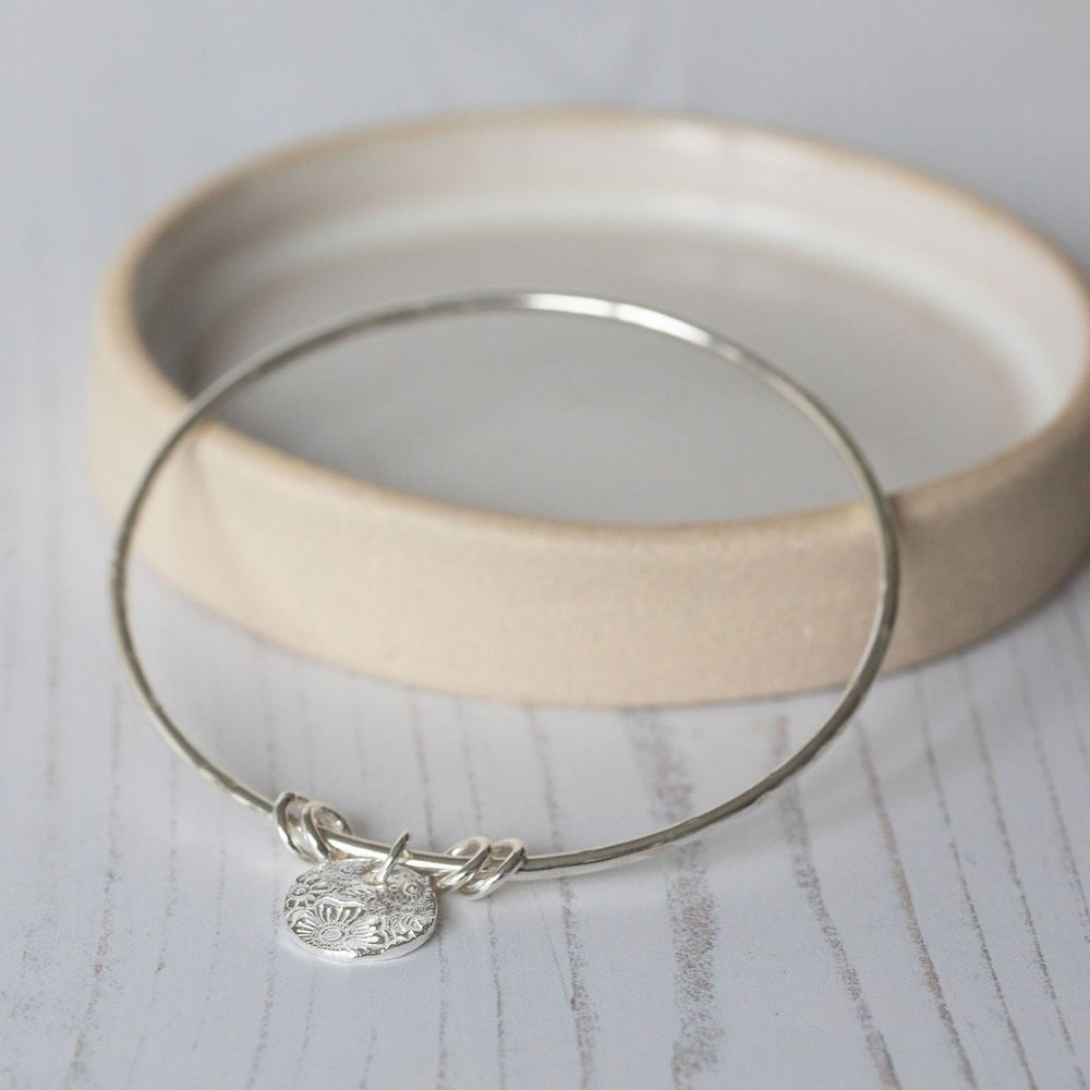 
                  
                    sterling silver textured circle charm bangle handmade by Lucy Kemp Jewellery 
                  
                
