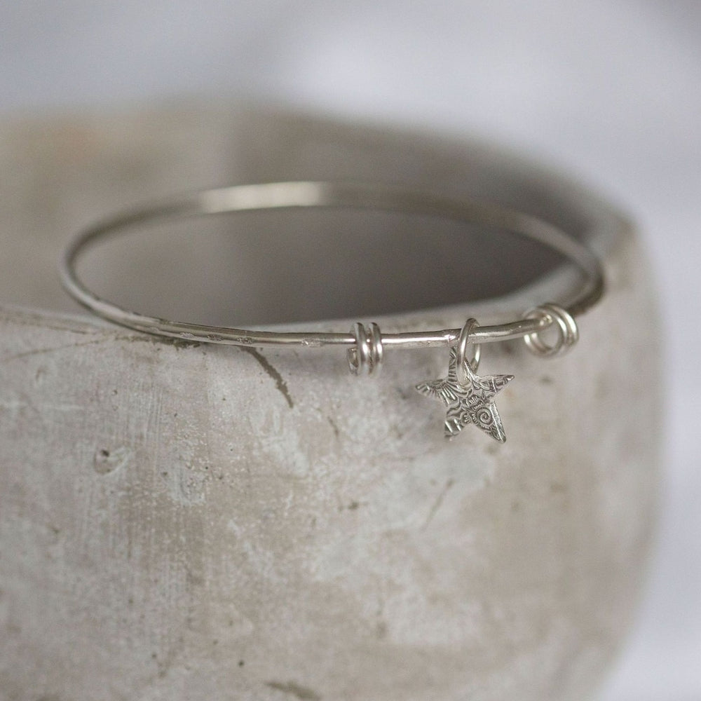 
                  
                    sterling silver textured star charm bangle handmade by Lucy Kemp Jewellery
                  
                
