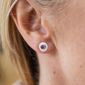 
                  
                    Worn Amethyst and sterling silver birthstone small disc studs by Lucy Kemp Jewellery
                  
                