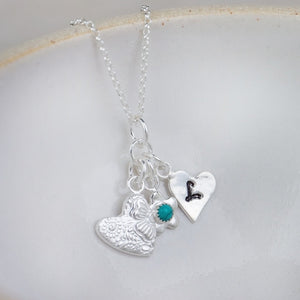 
                  
                    sterling silver and turquoise birthstone cluster necklace with hearts and flower charm by Lucy Kemp Jewellery 
                  
                