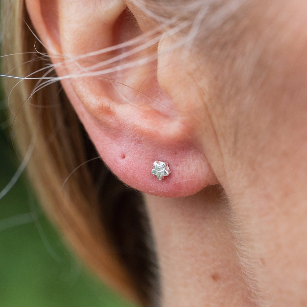
                  
                    sterling silver textured mini flower studs worn, handmade by Lucy Kemp Jewellery 
                  
                