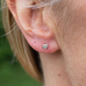 
                  
                    sterling silver textured mini heart studs worn, handmade by Lucy Kemp Jewellery 
                  
                