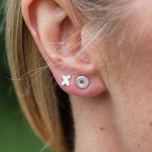 
                  
                    sterling silver textured mini hugs and kisses studs OX worn, handmade by Lucy Kemp Jewellery 
                  
                