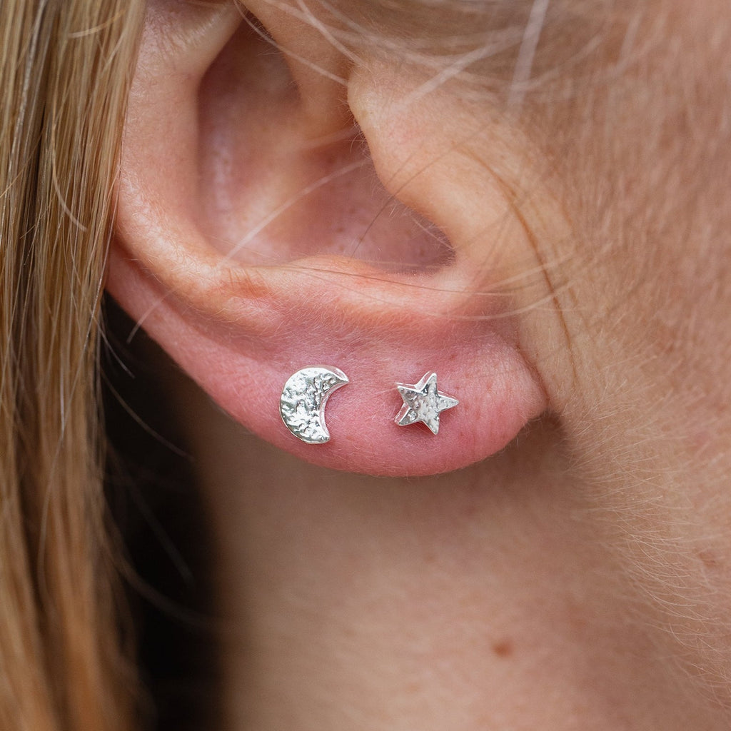sterling silver textured mini mismatch moon and star studs worn, handmade by Lucy kemp Jewellery