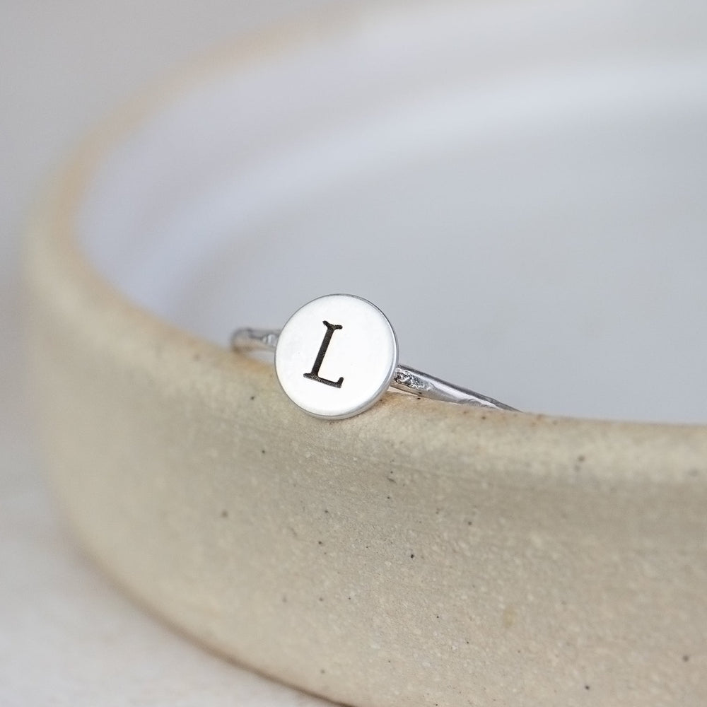
                  
                    sterling silver personalised initial charm ring handmade and engraved by Lucy Kemp Jewellery 
                  
                