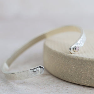 
                  
                    sterling silver and rose quartz birthstone and heart charm cuff by Lucy Kemp Jewellery
                  
                