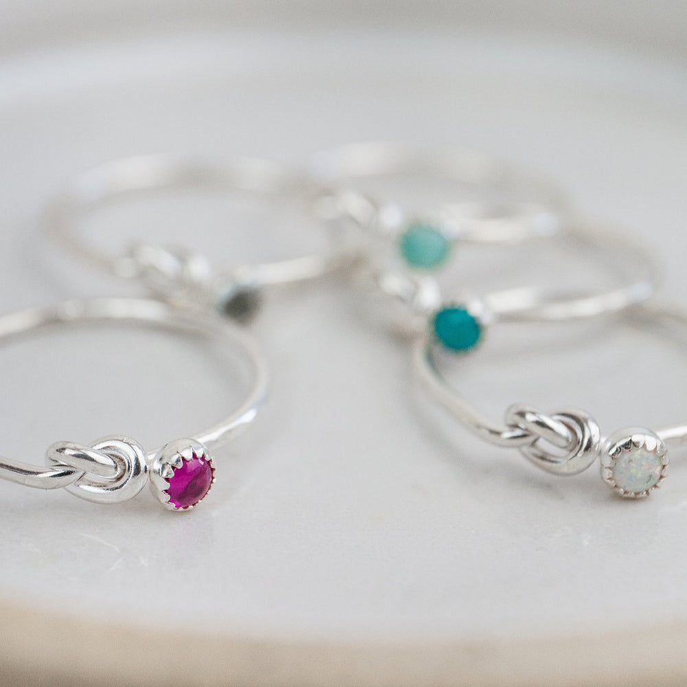 
                  
                    sterling silver birthstone love knot ring group shot 2 by Lucy Kemp Jewellery 
                  
                