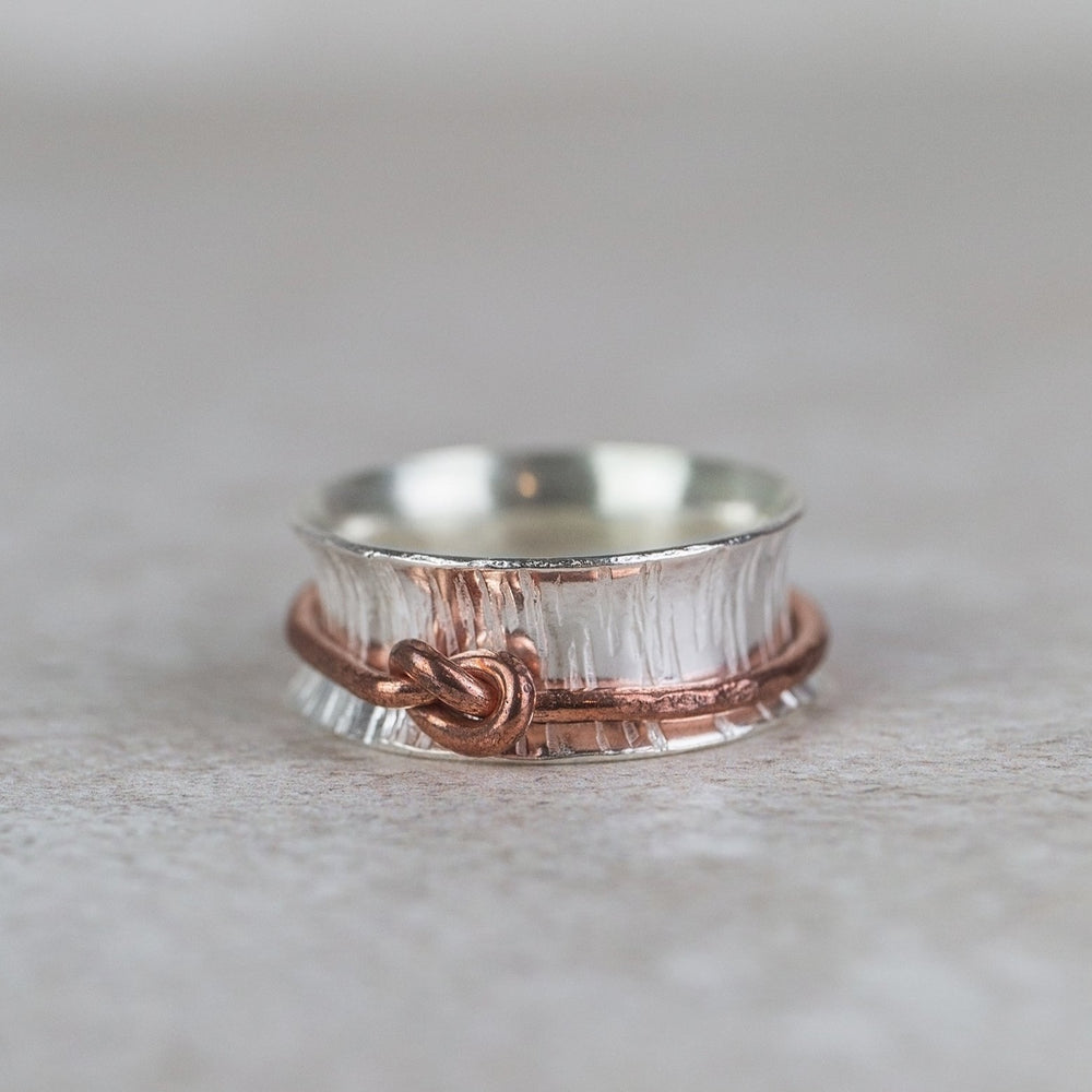sterling silver spinner ring with copper love knot , handmade by Lucy Kemp Jewellery 