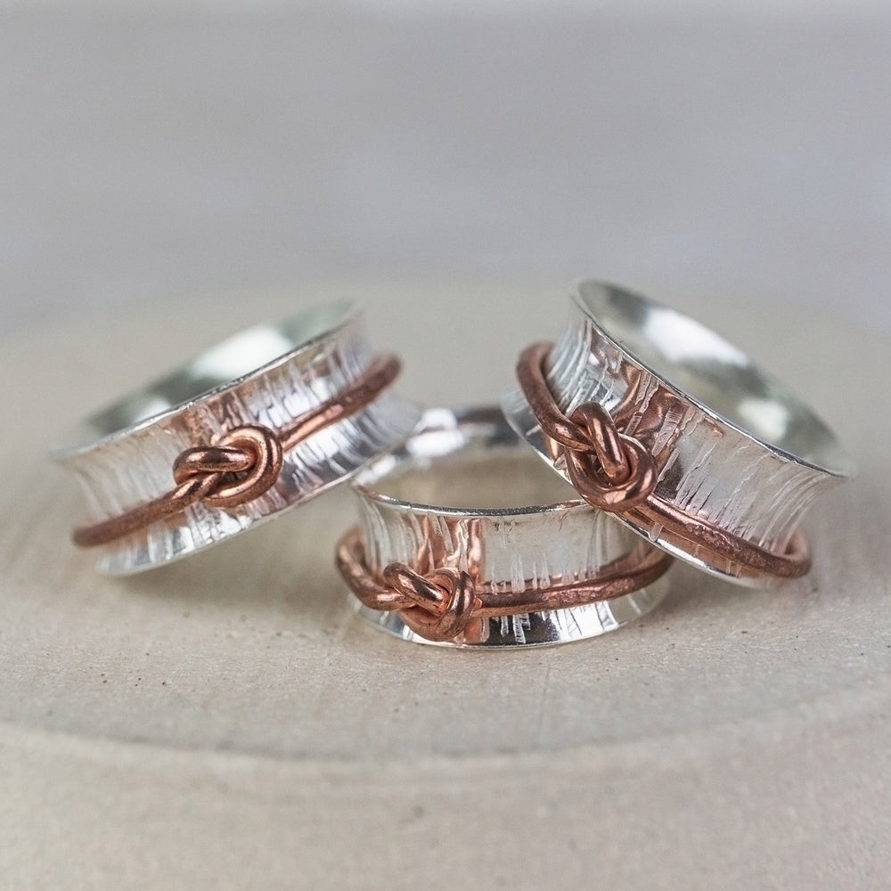 
                  
                    sterling silver spinner ring with copper love knot , handmade by Lucy Kemp Jewellery - group shot
                  
                