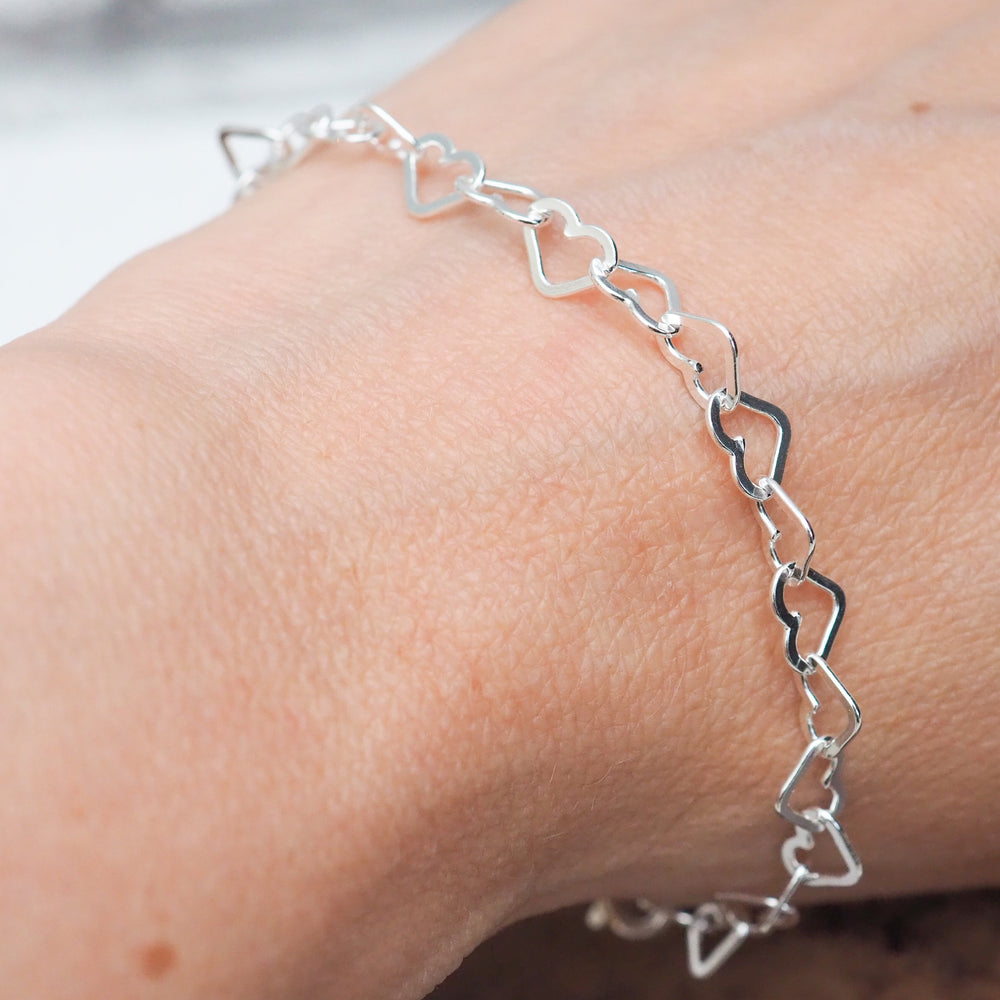 
                  
                    worn sterling silver delicate small heart link bracelet made by Lucy Kemp Jewellery
                  
                