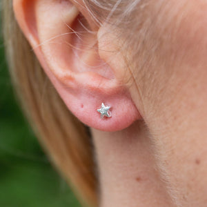 
                  
                    sterling silver textured mini mismatch moon and star studs, star worn, by Lucy Kemp Jewellery 
                  
                