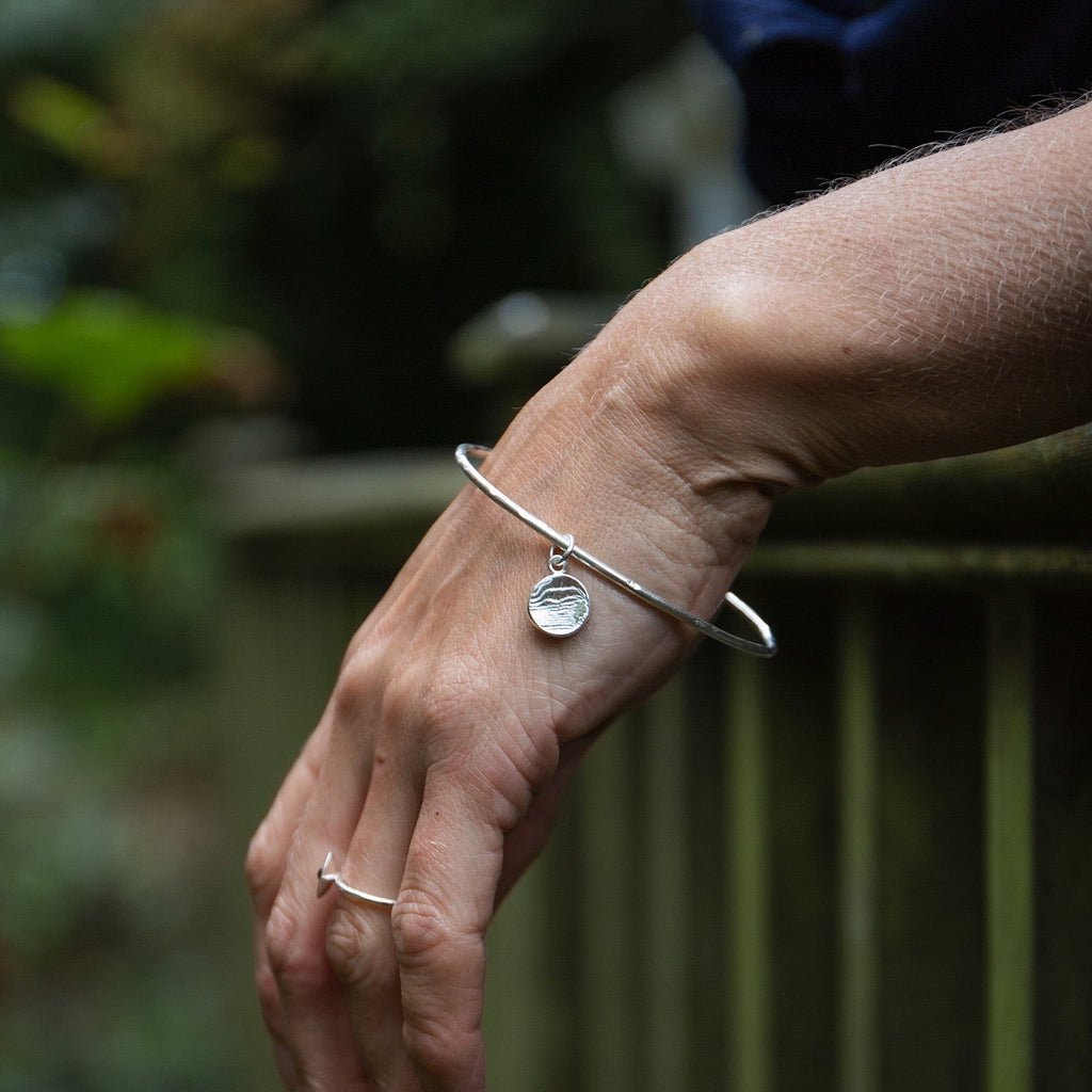 sterling silver small circle cuttlefish charm bangle handmade by Lucy Kemp Jewellery - worn image