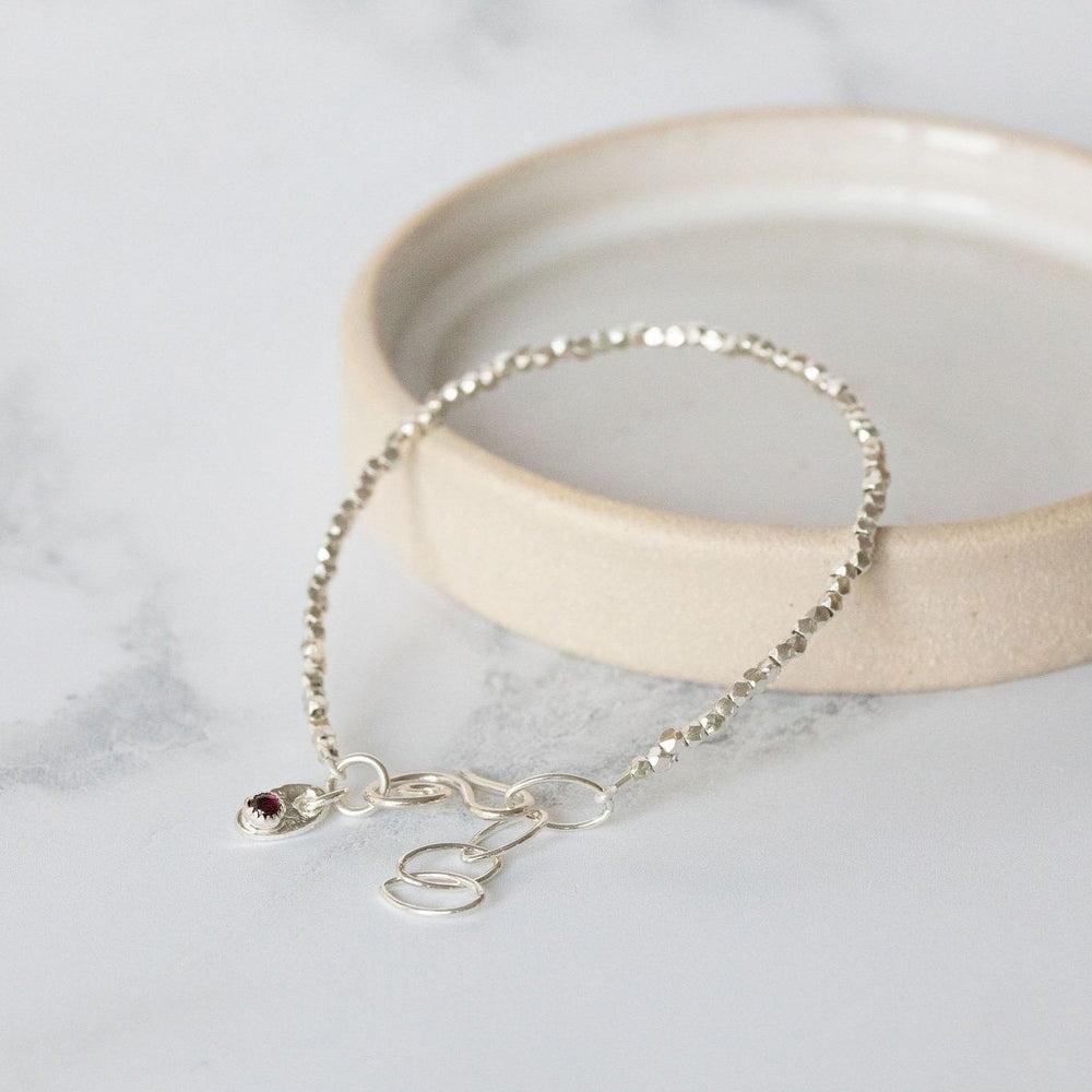 
                  
                    sterling silver mini nugget birthstone bracelet handmade by Lucy Kemp Jewellery with garnet
                  
                