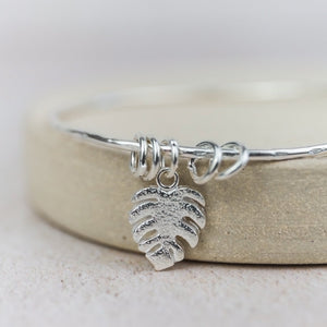 
                  
                    sterling silver monstera charm bangle handmade by Lucy Kemp Jewellery 
                  
                