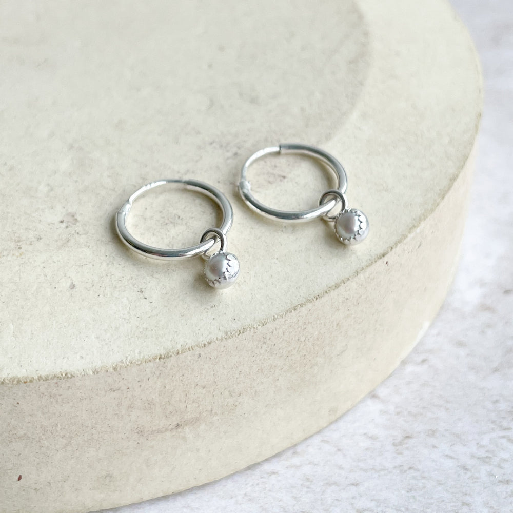 
                  
                    Sterling silver and pearl birthstone huggie sleeper hoops handmade by Lucy Kemp Jewellery
                  
                