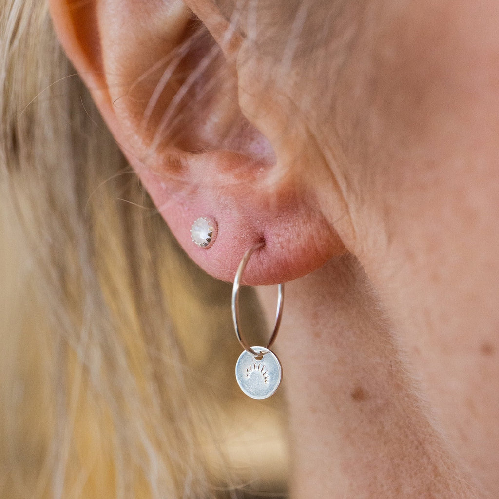 handmade sterling silver stamped hoop charm with eyelashes hand stamped on the front by Lucy Kemp Jewellery worn