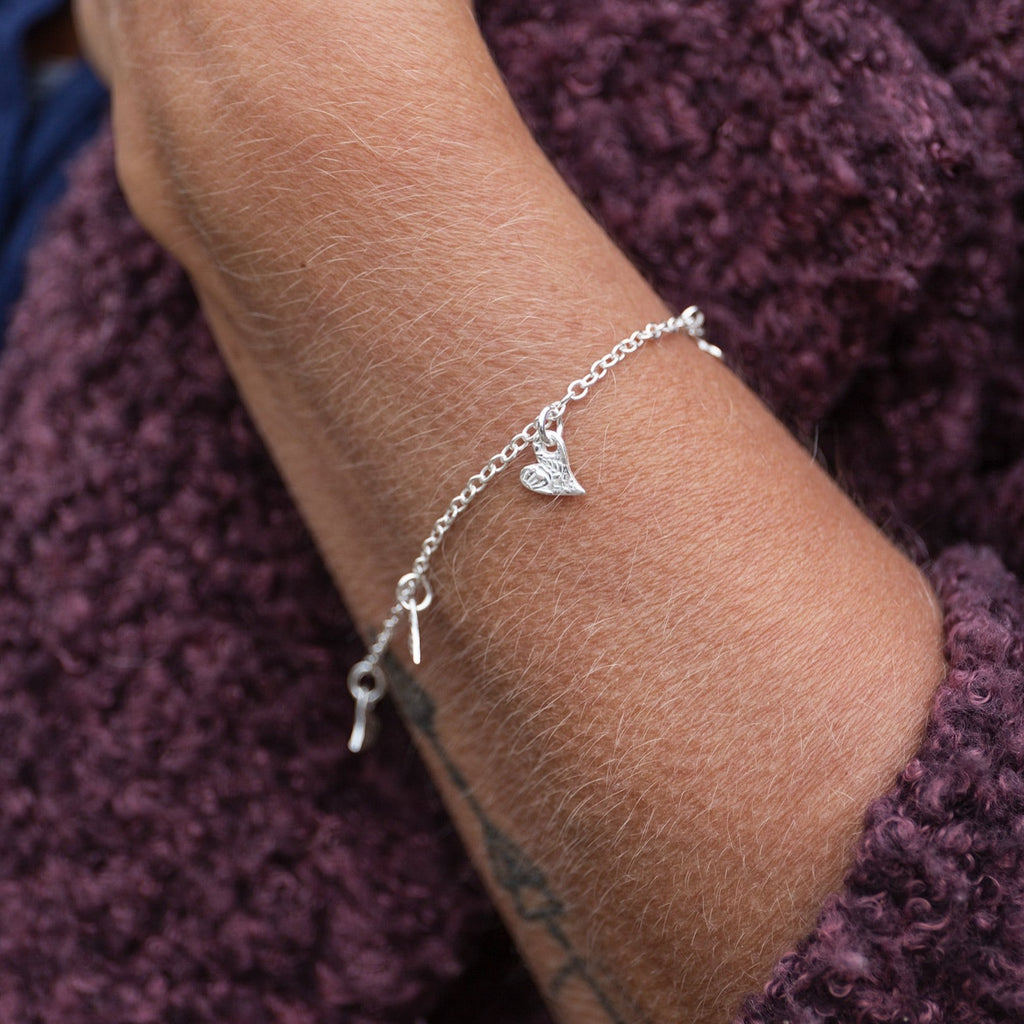 sterling silver textured tilted heart charm bracelet with delicate textures handmade by Lucy Kemp Jewellery, worn image
